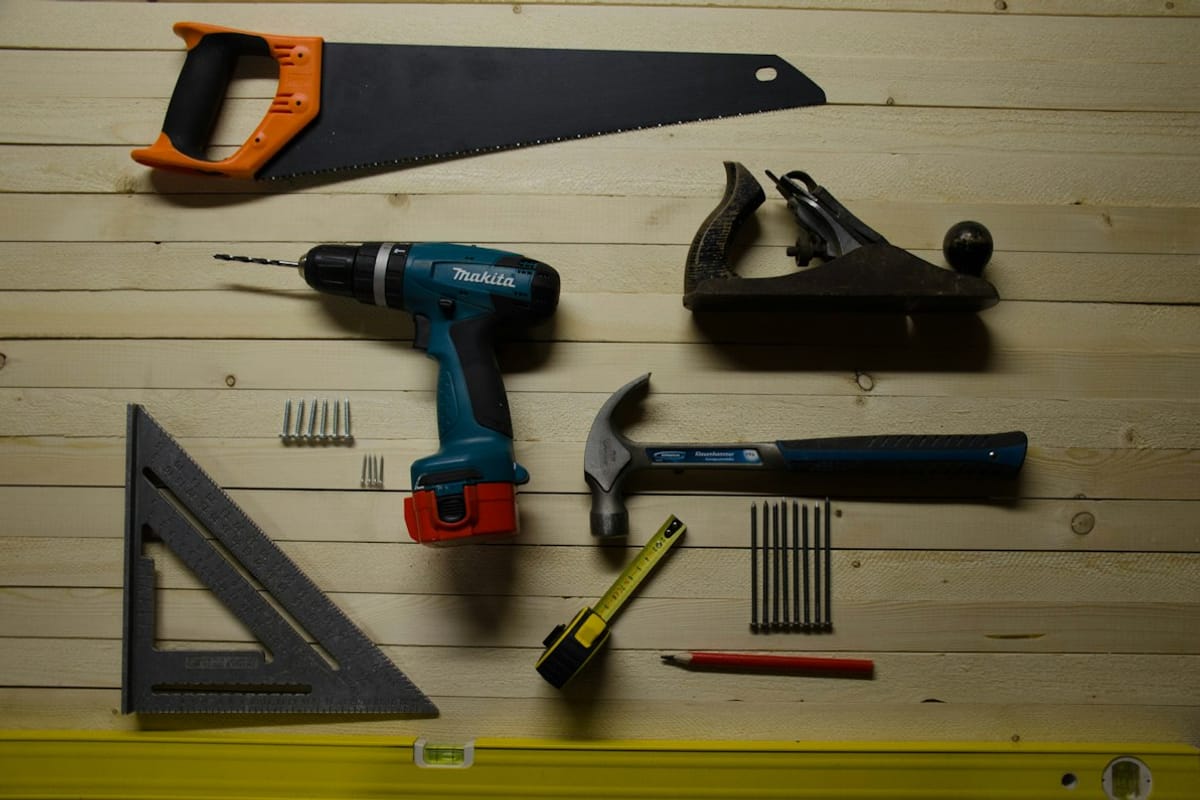 Assorted hand tools on a wooden surface